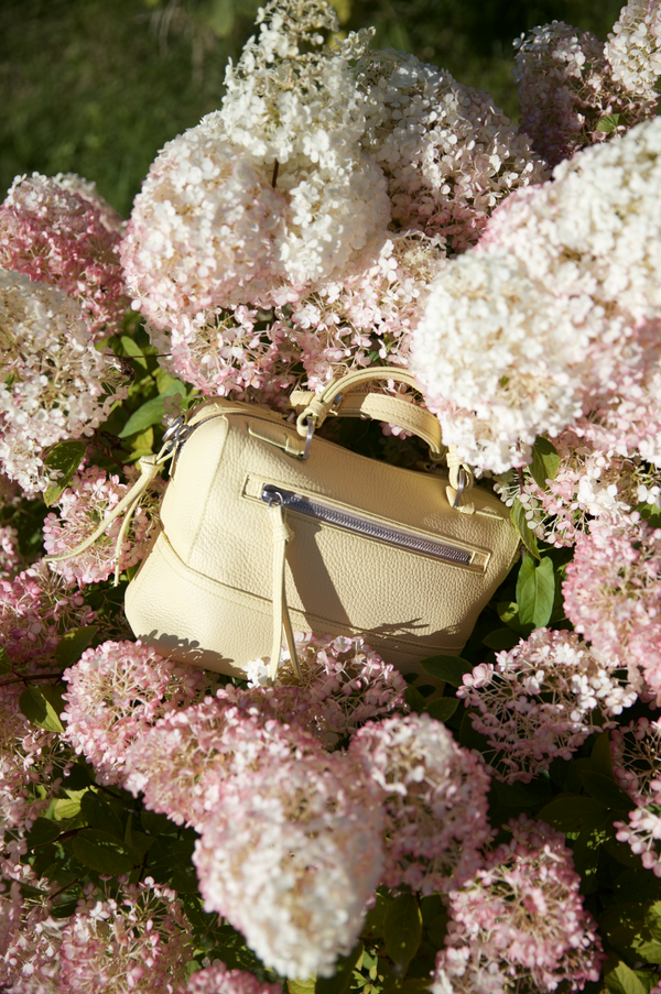 Yellow Sorbet Halm handbag among pink and white hydrangea flowers. Limited edition leather bags from Halm Collective Concept Store, Jumeirah, Dubai.
