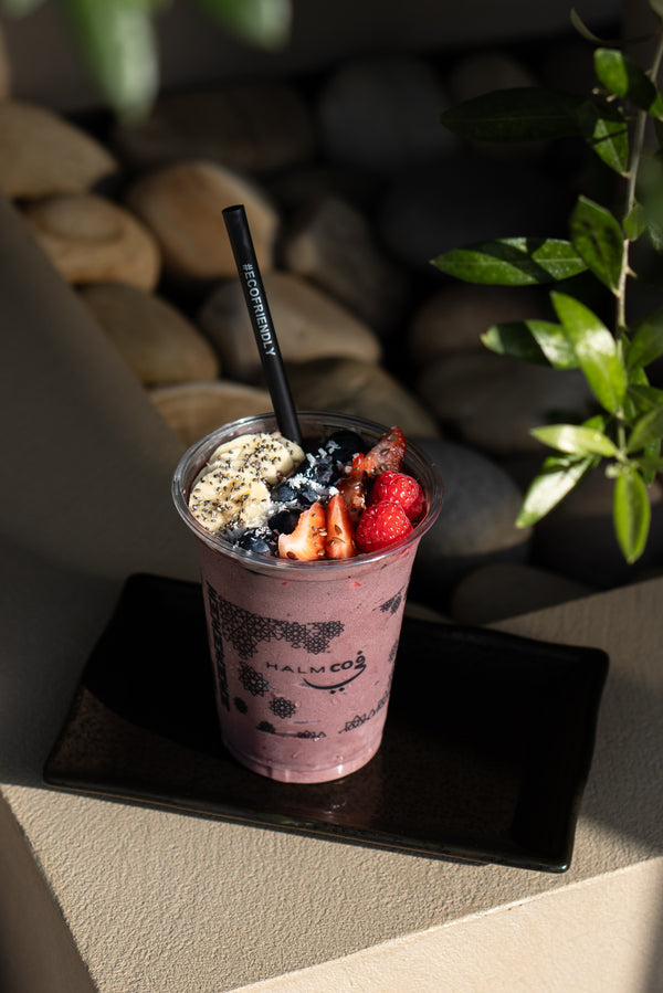 Açaí bowl topped with fresh fruits, granola, coconut flakes, and chia seeds, served in a rustic bowl at Halm Cafe.