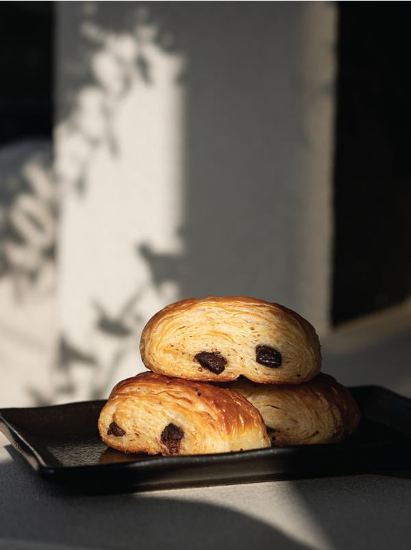 Two chocolate croissants on a black plate outside at the Halm cafe, Jumeirah Dubai.