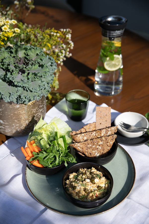 High-protein tuna bowl served with shredded carrots, fresh lettuce, a slice of rye bread, and a piece of sourdough on the side.