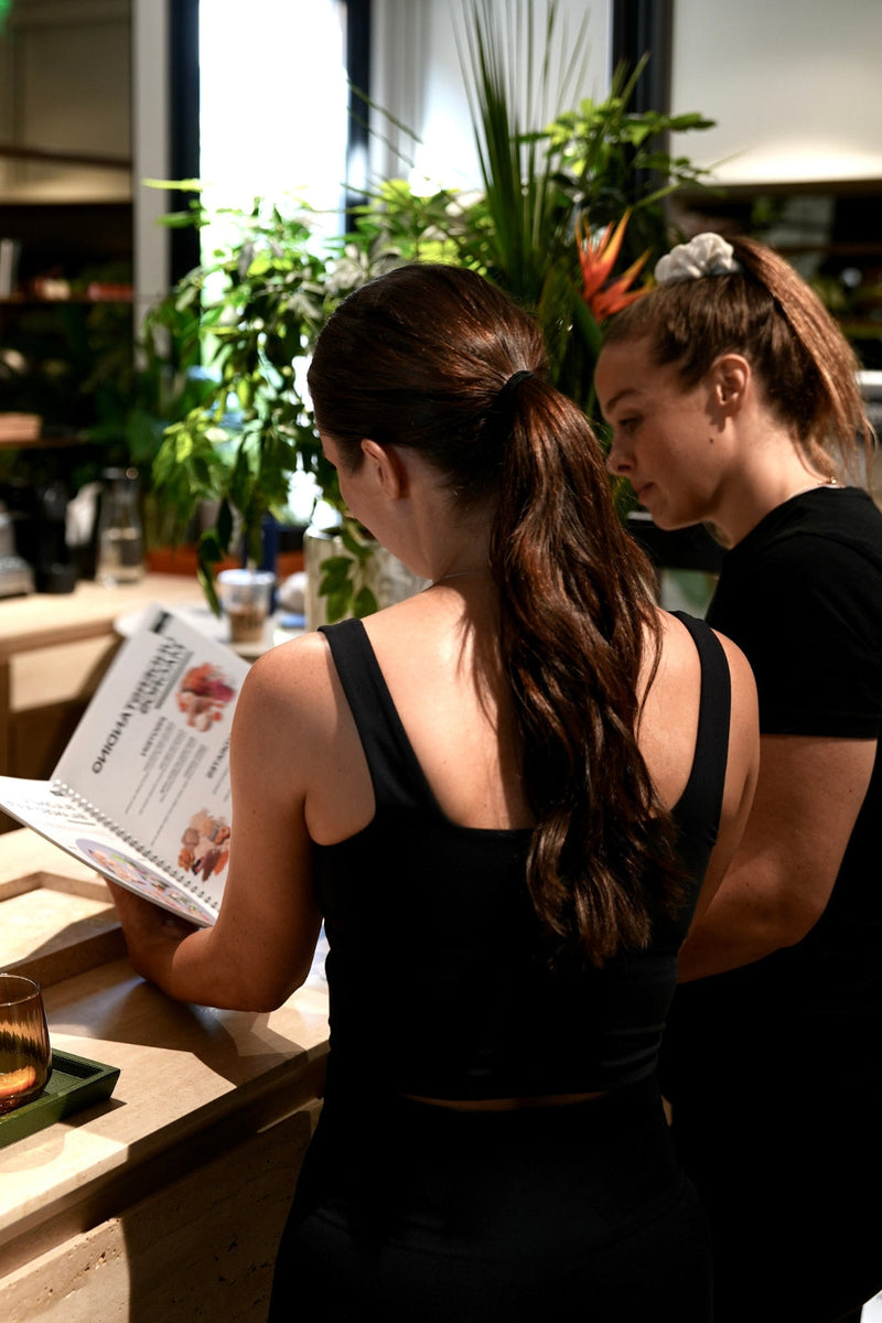 female personal trainer showing a client a nutrition book